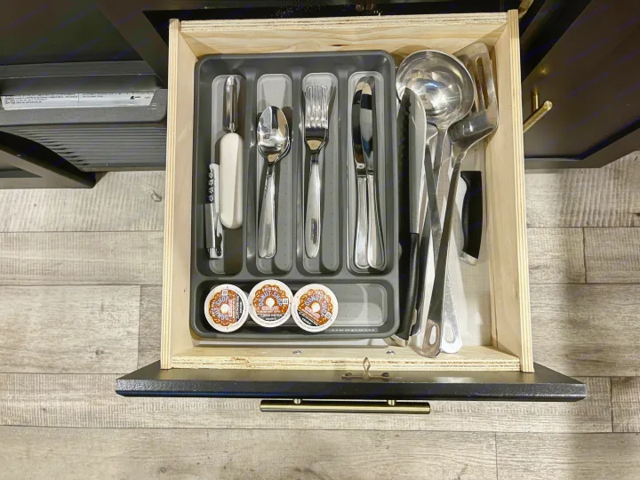 RV rental kitchen drawer showing essential utensils and Keurig coffee pods for on-the-go convenience.. Keystone RV Springdale 2022