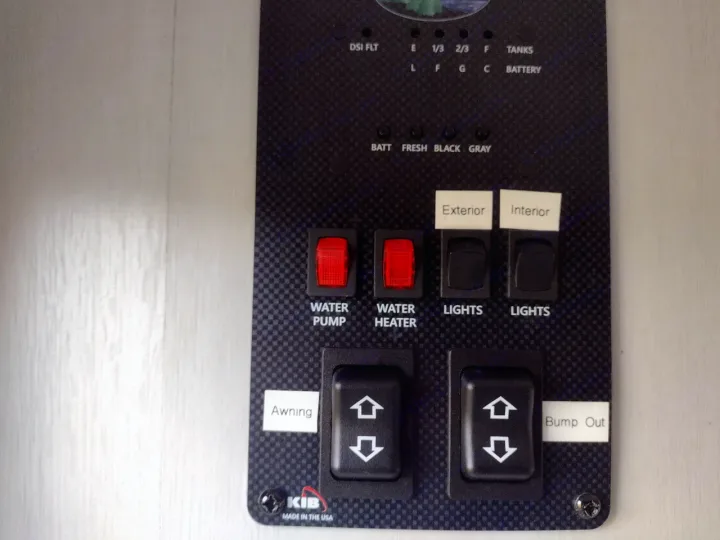 RV rental control panel displays tank/battery levels & switches for water pump, heater, lights, awning, bump out.. Forest River Wildwood FSX 2022
