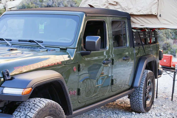 Green Jeep Gladiator pickup with rooftop tent, perfect for an off-road RV rental adventure and camping.. Fiat Jeep Gladiator 2023