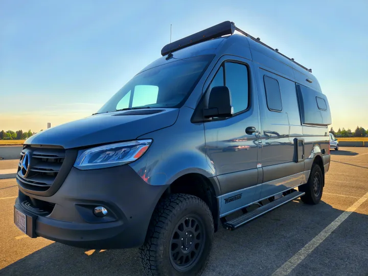 A sleek grey Mercedes-Benz Sprinter Winnebago camper van, perfect for your next RV rental. Parked outdoors.. Winnebago Revel 2022