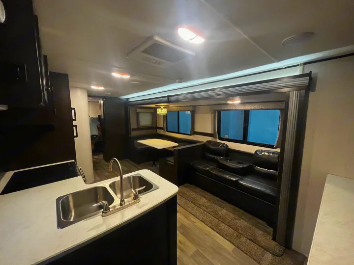 Modern RV rental interior with kitchen, dining, and living areas. Bright and clean for your travels.. Heartland RVs Pioneer 2020