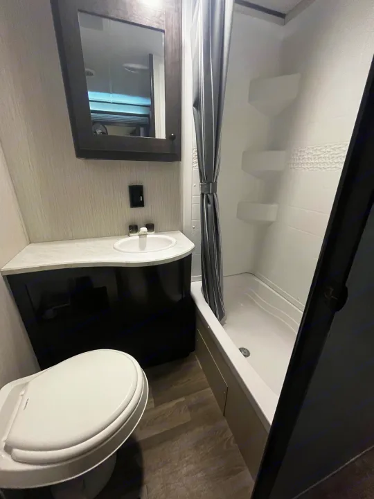 A modern, compact RV rental bathroom with vanity, sink, mirror, toilet, and shower/tub. Ready for your adventures.. Heartland RVs Pioneer 2020