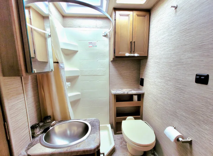 RV rental bathroom features a compact sink, toilet, and shower stall, designed for efficient use of space.. Thor Motor Coach Four Winds 2021