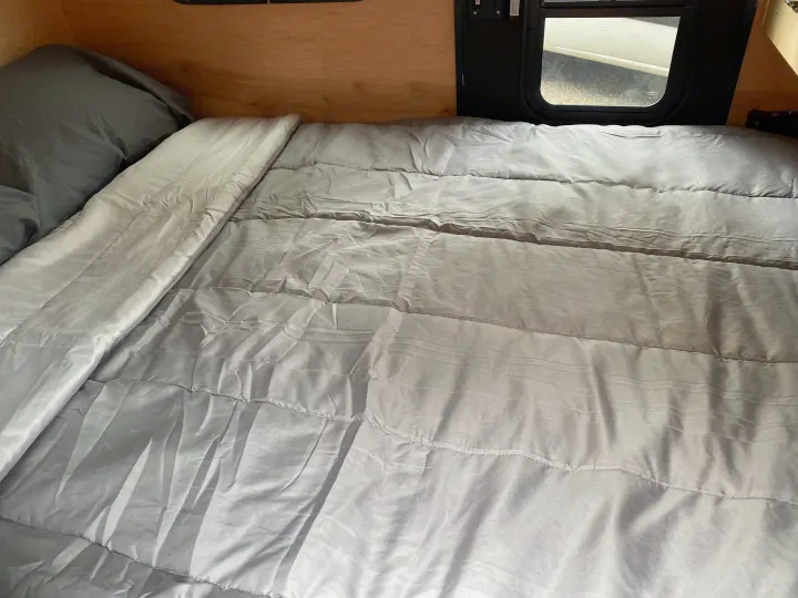 Cozy light grey bed and pillow inside an RV, perfect for a comfortable RV rental stay.. TC Tear Drop TC Original 2022