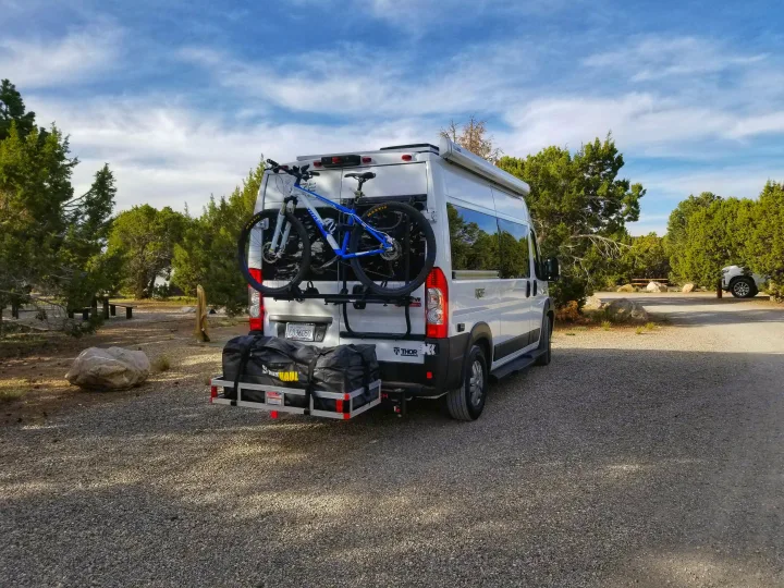 Thor Rize RV rental camper van with mountain bike & cargo carrier, parked in a scenic outdoor setting.. Thor Rize 2022