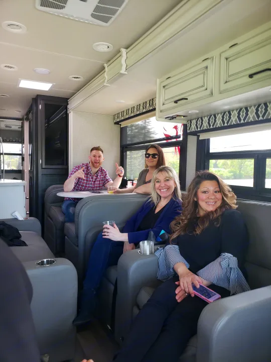 Group of friends relaxing inside a comfortable RV rental, showcasing the cozy interior for travel adventures.. Jayco Precept 2020