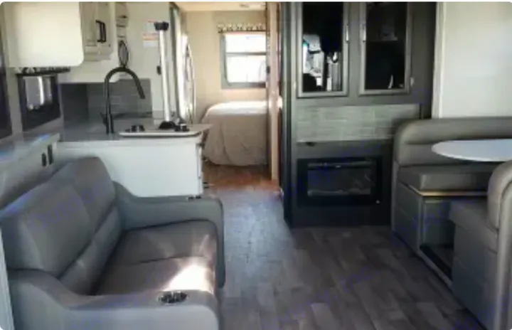 Modern RV rental interior: lounge with cupholders, kitchen, dining booth, fireplace, and rear bedroom.. Jayco Precept 2020