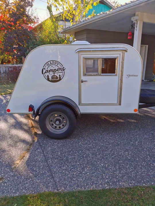 A bright white teardrop camper with "Happy Campers" decal, ideal for your next rv rental adventure.. Custom Built Custom Built 2021