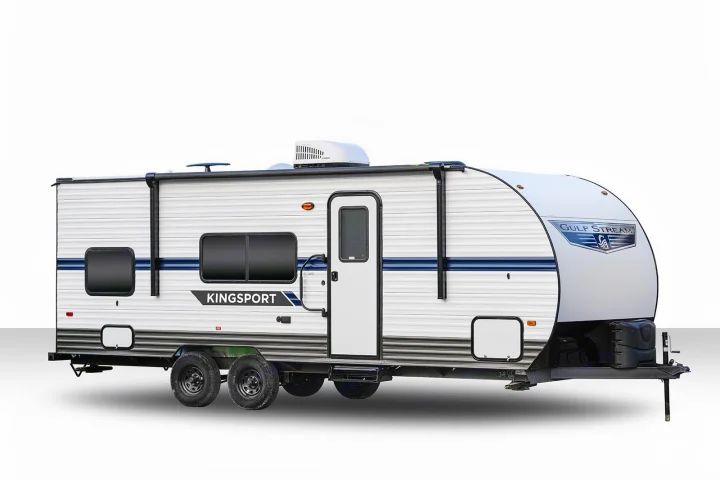 White Gulf Stream Kingsport travel trailer, ideal for your next RV rental. Features blue stripes, windows, and a prominent entry door.. Gulf Stream Kingsport 2022