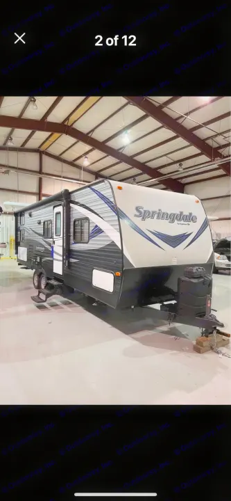 Springdale travel trailer, a versatile RV rental option, displayed indoors in a bright setting.. Keystone RV Springdale 2019