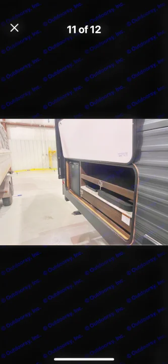 Black RV rental's side compartment reveals an outdoor kitchen with a mini-fridge and pull-out prep station.. Keystone RV Springdale 2019