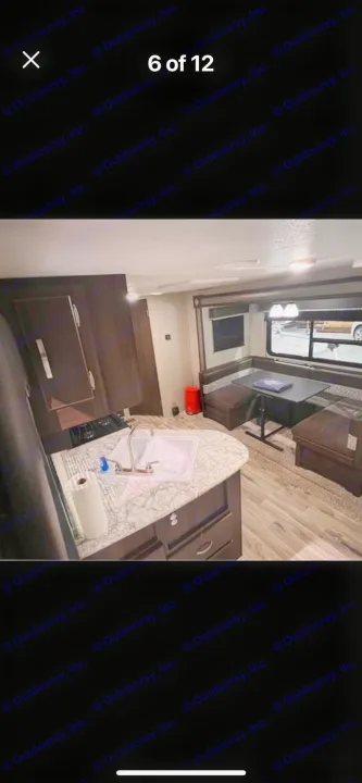 Inside an RV rental: view of the kitchen counter with sink and a cozy U-shaped dinette with seating.. Keystone RV Springdale 2019