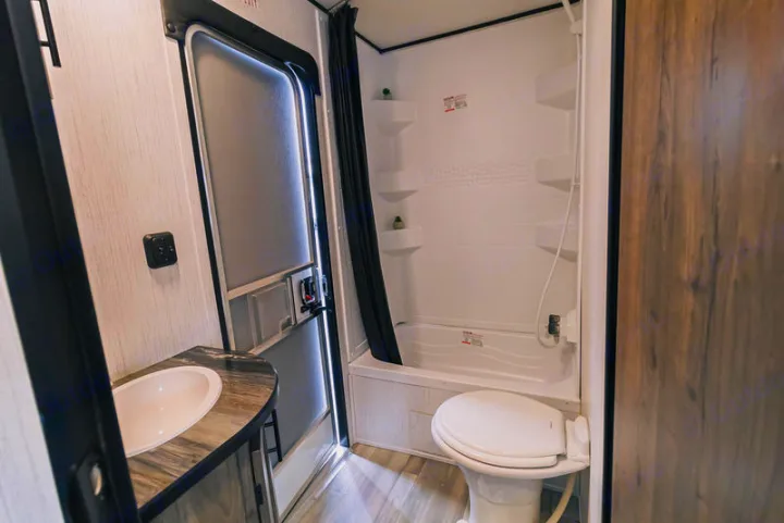 Compact RV rental bathroom: features a toilet, shower/tub, and sink. Perfect for travel comfort.. Heartland Pioneer 2022