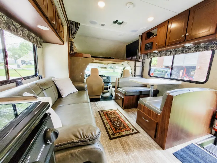 Spacious RV rental interior: living area, dining booth, kitchen counter, and driver's cab. Perfect for travel.. Forest River Sunseeker LE 2018