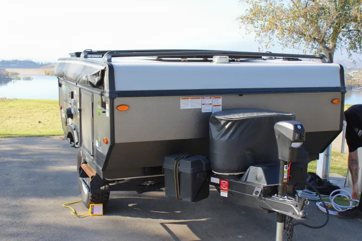 RV rental pop-up camper by a lake, being set up. Perfect for outdoor adventures and relaxation.. Forest River Rockwood ESP 2021