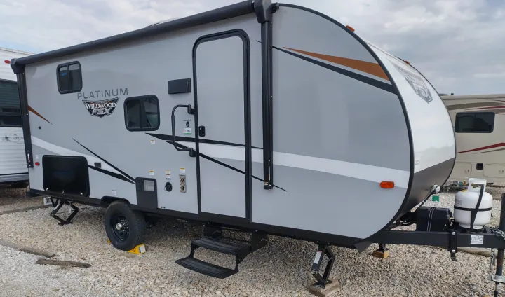 Grey Wildwood FSX Platinum travel trailer for rv rental. Side view shows door, steps, windows, and front propane.. Forest River Other 2022