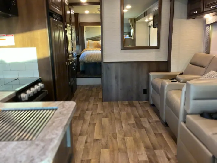 Interior view of an RV rental showcasing its kitchen, living area with recliners, and rear bedroom. Perfect for your next adventure.. Jayco Greyhawk 2020