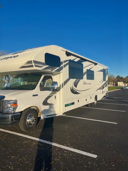 Jayco Greyhawk RV rental: A white Class C motorhome parked in a sunny lot, ready for road trips and adventure.. Jayco Greyhawk 2020