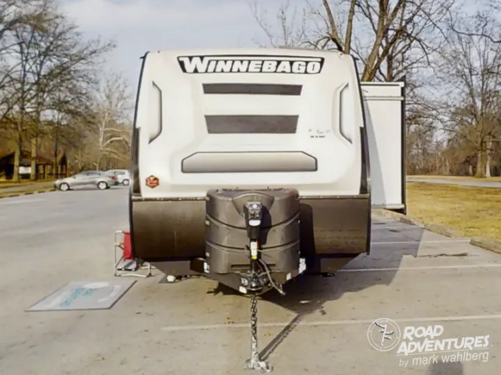 Front of a parked Winnebago travel trailer, an RV rental option, with a propane tank, ready for camping trips.. Winnebago Micro Minnie 2100BH 2023