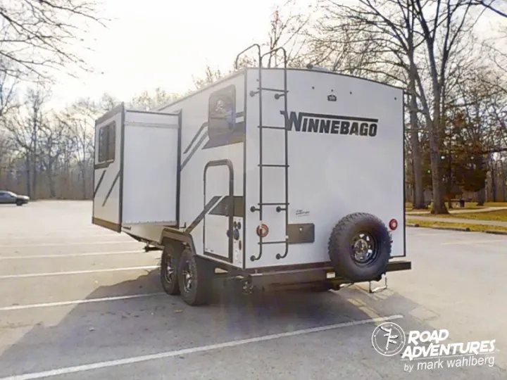 White Winnebago travel trailer with pop-out, ladder & spare tire, ready for your rv rental road adventures.. Winnebago Micro Minnie 2100BH 2023