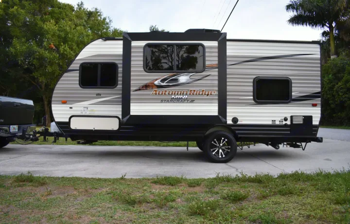 Spacious Autumn Ridge Mini travel trailer hitched to a truck on a concrete driveway, ideal for your next RV rental adventure.. Starcraft Autumn Ridge Mini 2017