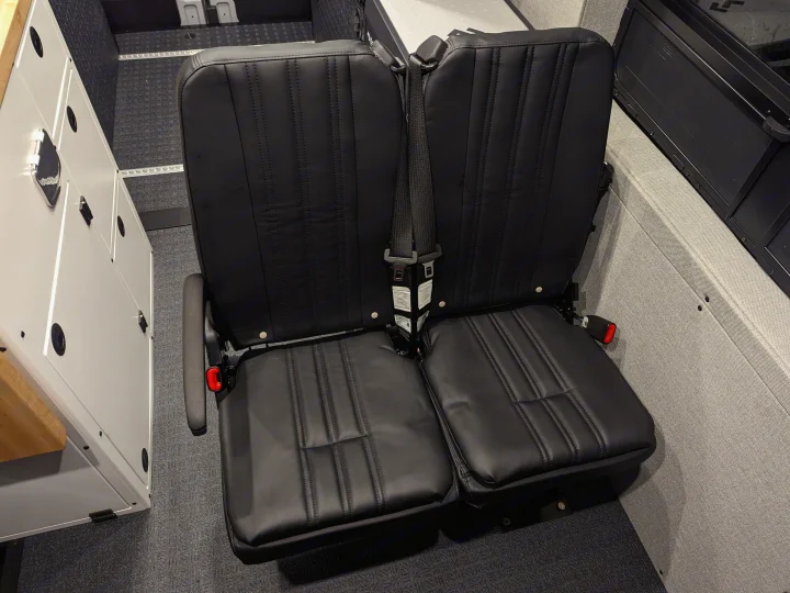 Modular black passenger seats with secure seatbelts on floor rails, ideal for an RV rental.. Grit Overland GO A/T 2022