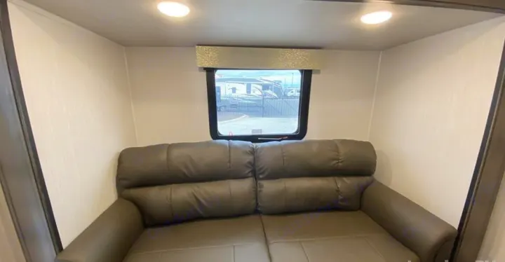 RV rental interior: Comfortable dark gray sofa, window with outdoor view, and bright ceiling lights.. Forest River Other 2022