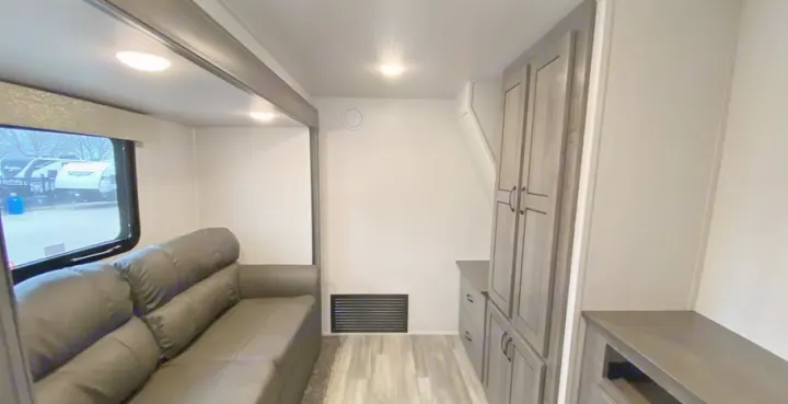 Explore the spacious interior of this modern RV rental! Features a comfortable sofa, large window, and ample storage cabinets.. Forest River Other 2022