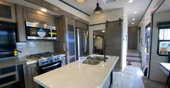 Explore this modern RV rental kitchen featuring a large island, stainless steel appliances, and inviting living space.. Forest River Other 2022