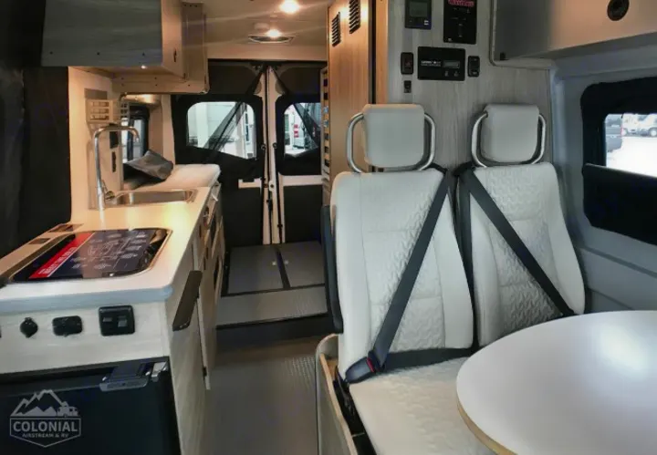 This modern RV rental features a compact kitchen, dinette seating, and rear door access, perfect for travel.. Winnebago Solis 2021