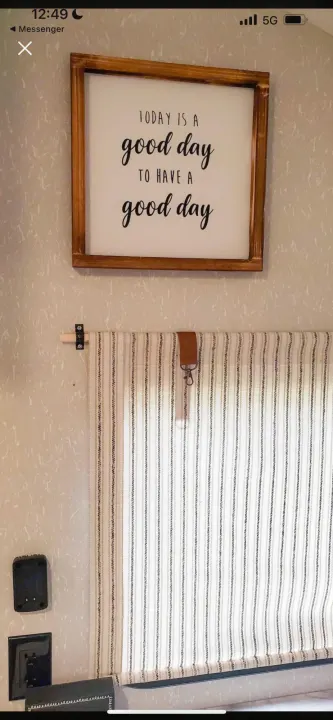 Inviting RV rental interior featuring a "good day" sign, striped fabric shade, and compact wall-mounted details.. Forest River Cherokee Wolf Pup 2022