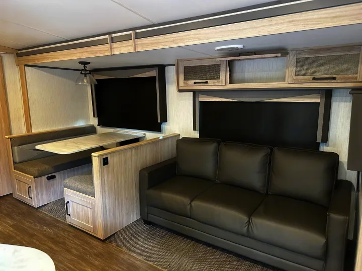 Step inside this modern RV rental! Features include a cozy dinette with a table and a comfy sofa in a compact living area.. Twilight RVS Signature 2022
