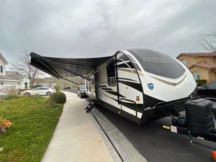 Outback Ultralite RV travel trailer rental with extended awning & steps in a residential setting.. Keystone RV Outback Ultra-Lite 2021