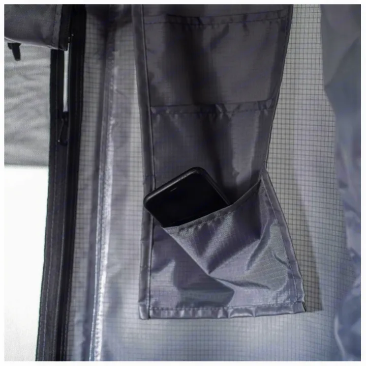 RV rental interior: grey fabric wall with a zipper, mesh window, and a convenient pocket holding a phone.. Smittybilt Hardshell RTT 2022