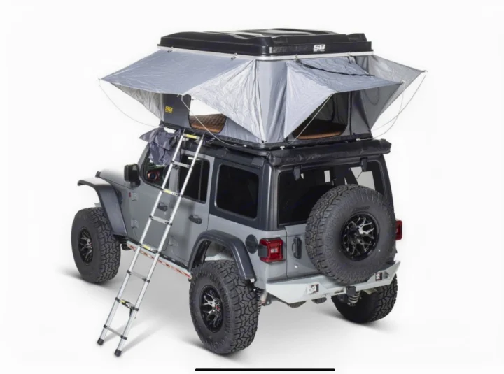 RV rental adventure: Gray Jeep Wrangler with deployed SB rooftop tent & ladder. Perfect for camping!. Smittybilt Hardshell RTT 2022