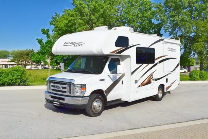 A bright white Class C Freedom Elite RV, with brown and black decals, parked on asphalt; ready for rv rental adventures.. Thor Freedom Elite 2016