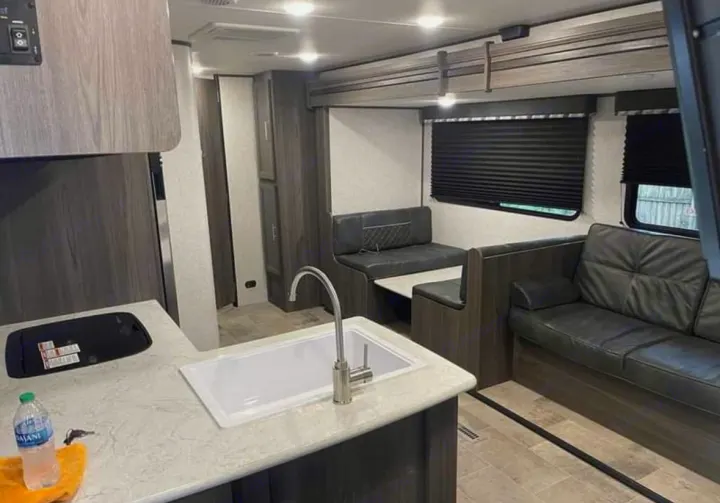 This modern RV rental features a full kitchen with sink, comfortable dinette, and a spacious sofa lounge area.. Dutchmen Kodiak SE 2021