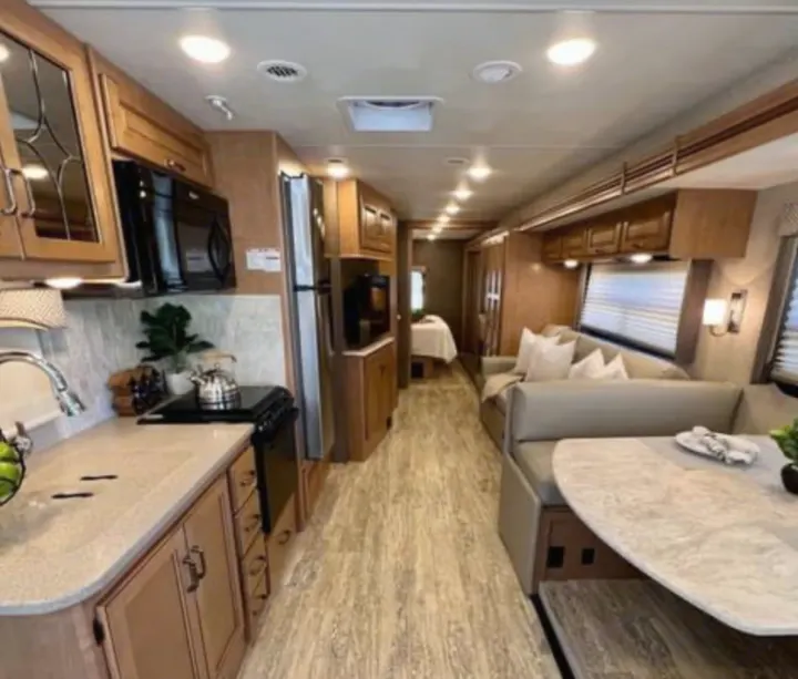 Spacious RV rental interior featuring a modern kitchen, living area, and bedroom.. Thor Motor Coach Hurricane 2020
