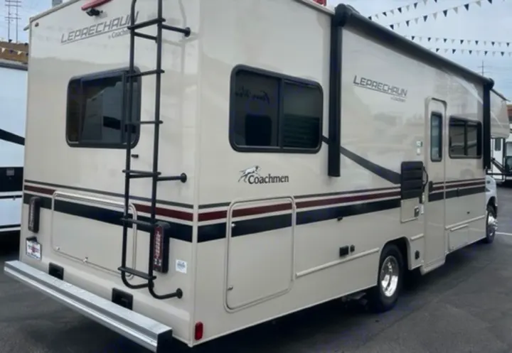 Light tan Coachmen Leprechaun RV, perfect for your next rv rental adventure. Features rear ladder & side awning.. Other Leprechaun 2022