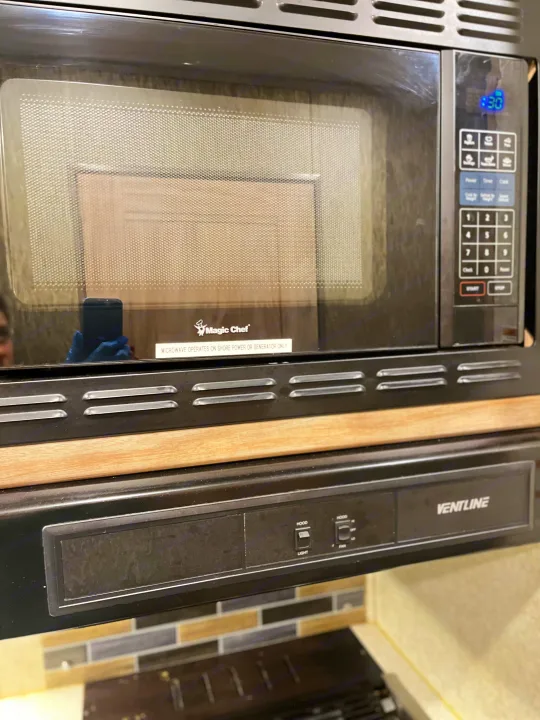 An RV rental kitchen features a Magic Chef microwave (shore power only) and a Ventline range hood setup.. Forest River Sunseeker 2019