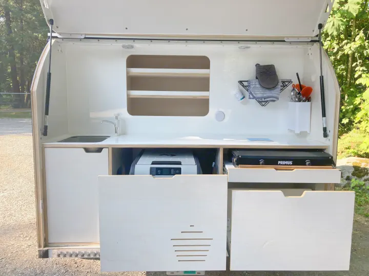 RV rental's clever outdoor kitchen with sink, stove, and fridge, ideal for compact travel and outdoor cooking.. droplet XL 2026