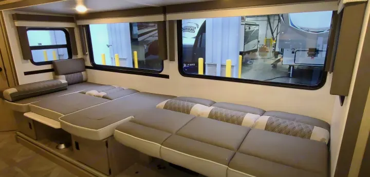 Modern **RV rental** dinette with gray modular cushions, transforming into a comfortable bed.. Forest River Other 2023