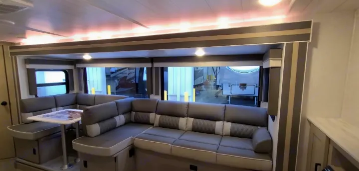 This RV rental boasts a spacious, modern interior with a comfortable gray U-shaped sofa, dinette, and large windows.. Forest River Other 2023