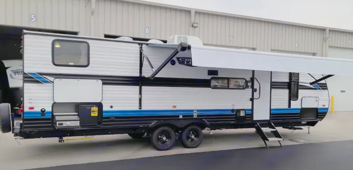 A pristine white and blue travel trailer with an extended awning and outdoor kitchen, ideal for RV rental adventures.. Forest River Other 2023