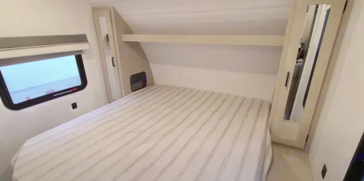 RV rental: Interior of a cozy bedroom with striped bed, window, and mirrored cabinets. Ideal for road trips.. Forest River Other 2023