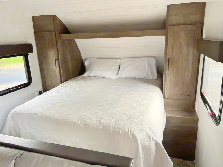 Comfortable RV rental bedroom with white bedding and built-in storage units. Ready for your next adventure.. Forest River EVO Select 268 BH 2022