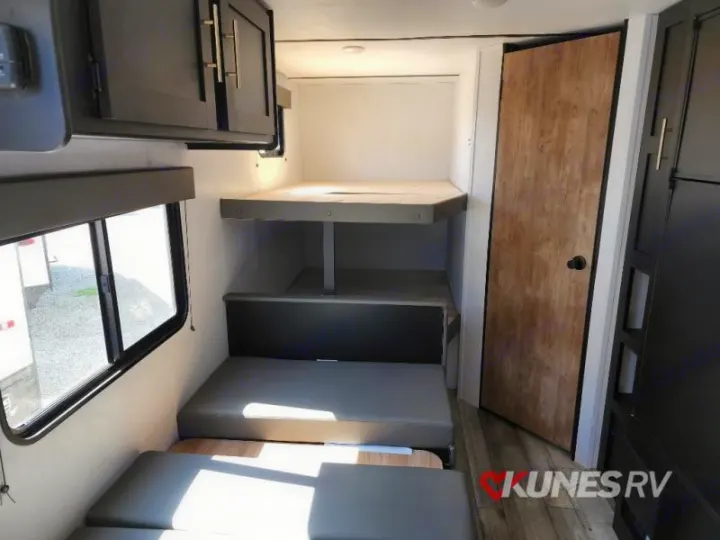 RV rental interior: View of bunk beds, convertible seating, and overhead cabinets. Ideal for a family's sleeping area.. Keystone Springdale 2022