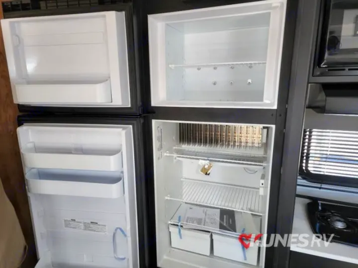 RV rental: Inside a clean, empty dual-door refrigerator, with upper freezer and lower fridge compartments, ready for your travels.. Keystone Springdale 2022