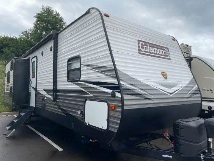 Modern gray and black Coleman travel trailer with steps down, perfect for an rv rental.. Dutchmen Coleman Lantern 2020