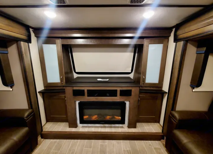 Cozy RV rental interior: entertainment center with fireplace, pull-down screen, and inviting leather seating.. Keystone RV Montana High Country Toy Hauler 2019